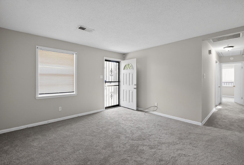 Carpeted spare room with attic access and a textured ceiling
