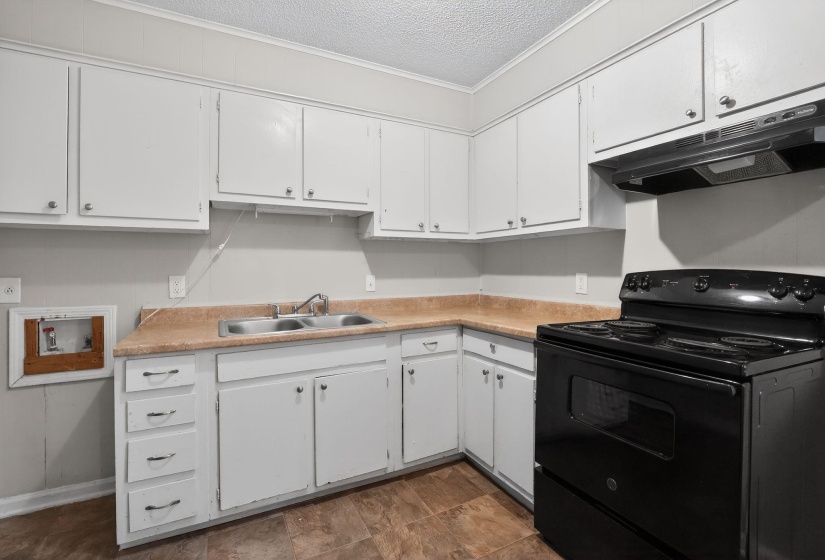 Kitchen featuring black / electric stove, light countertops, white cabinets, a textured ceiling, and extractor fan
