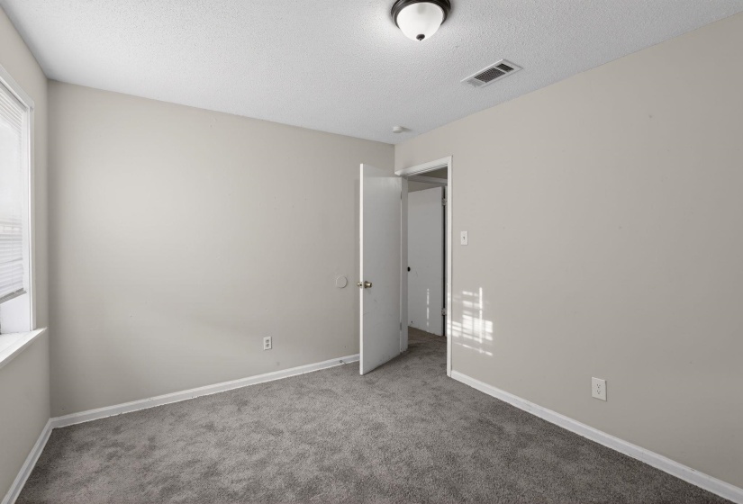 Empty room featuring carpet flooring and a textured ceiling