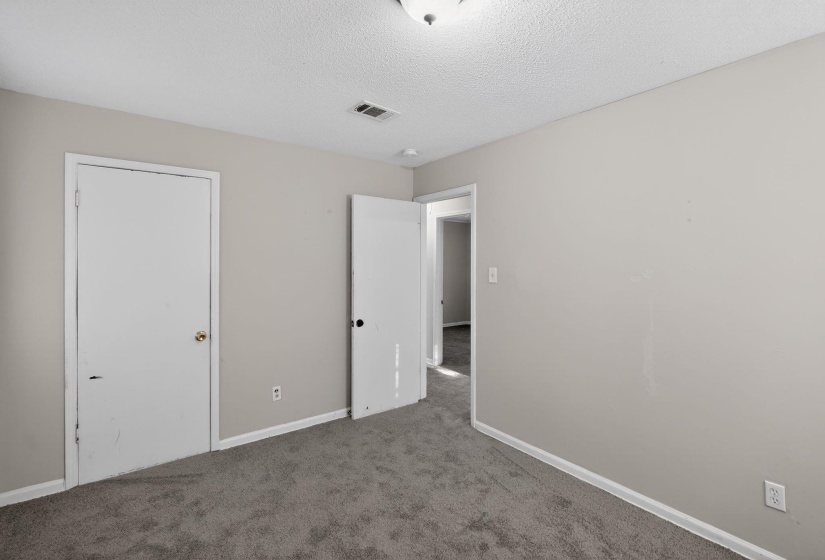 Unfurnished bedroom with carpet and a textured ceiling