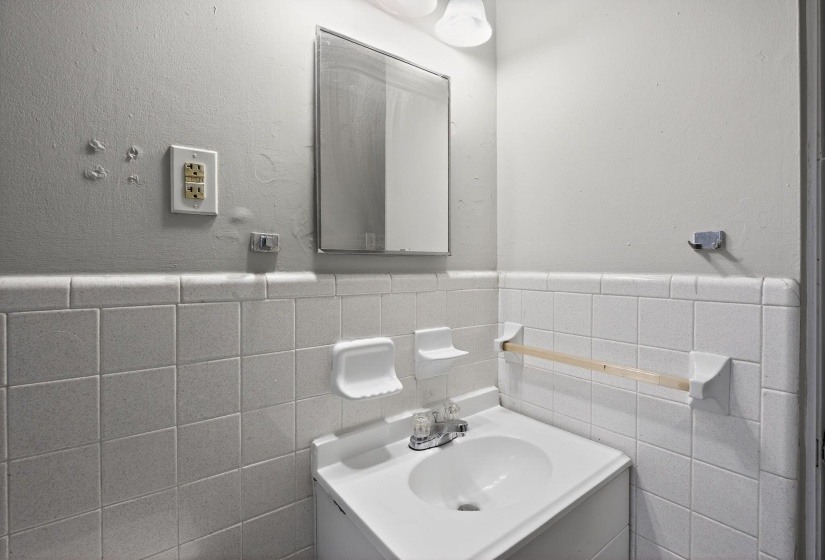 Bathroom with vanity, a wainscoted wall, and tile walls