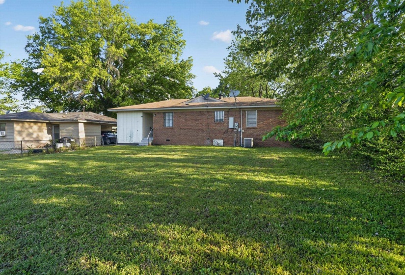 Rear view of property featuring crawl space, brick siding, and entry steps