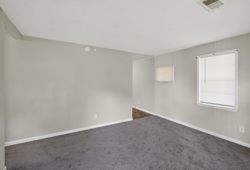 Unfurnished room featuring dark carpet and a textured ceiling