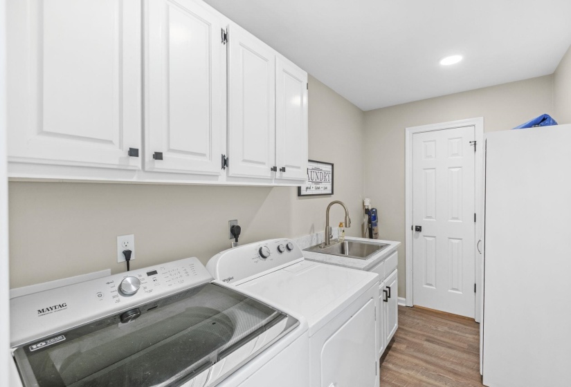Laundry room with cabinet space, light wood-style flooring, independent washer and dryer, and recessed lighting
