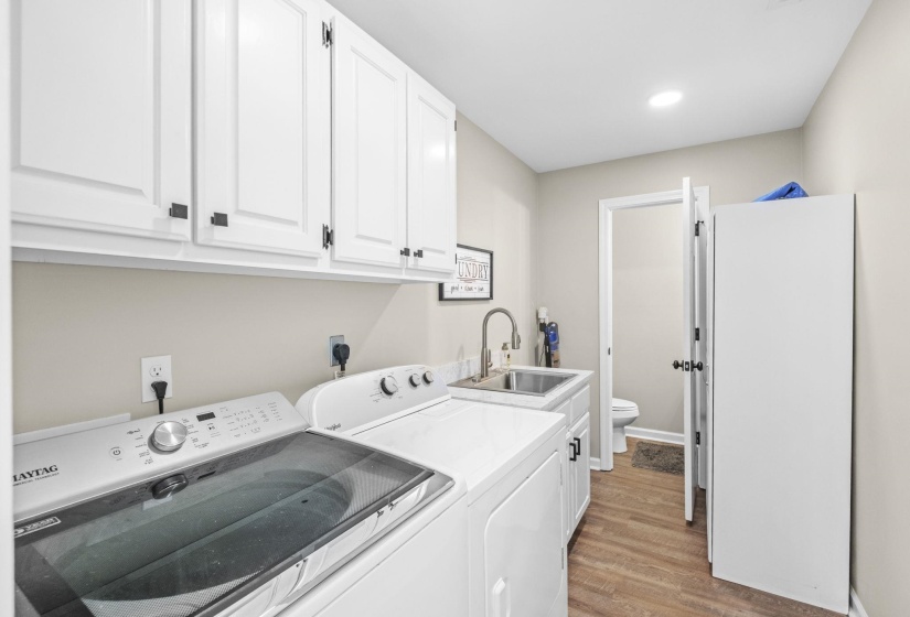 Laundry room featuring light wood finished floors, separate washer and dryer, cabinet space, and recessed lighting