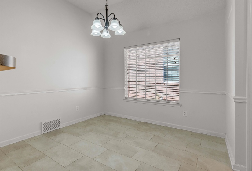 Spare room featuring hanging lights and light tile patterned floors