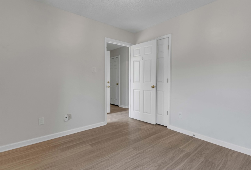 Empty room with wood finished floors and a textured ceiling