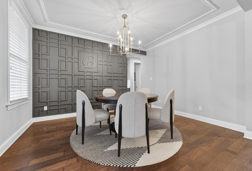 Dining room featuring an accent wall, dark wood-style flooring, hanging lights, and crown molding