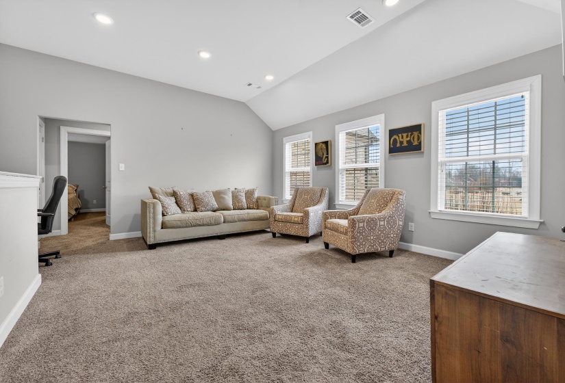 Living room featuring lofted ceiling, light colored carpet, and recessed lighting