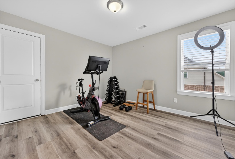 Exercise area featuring light wood-style floors and baseboards