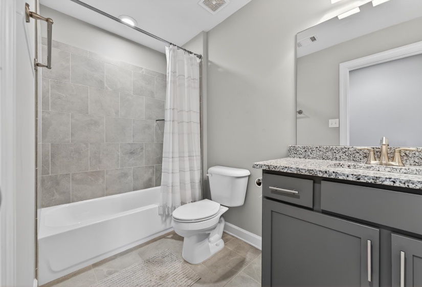 Full bathroom with vanity, shower / bath combo, and light tile patterned floors