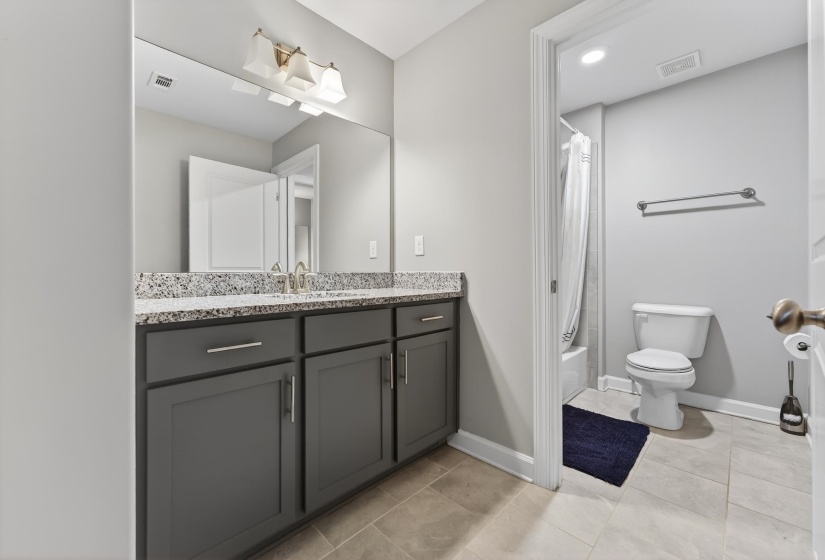 Full bathroom with vanity, shower / bathtub combination with curtain, light tile patterned flooring, and recessed lighting