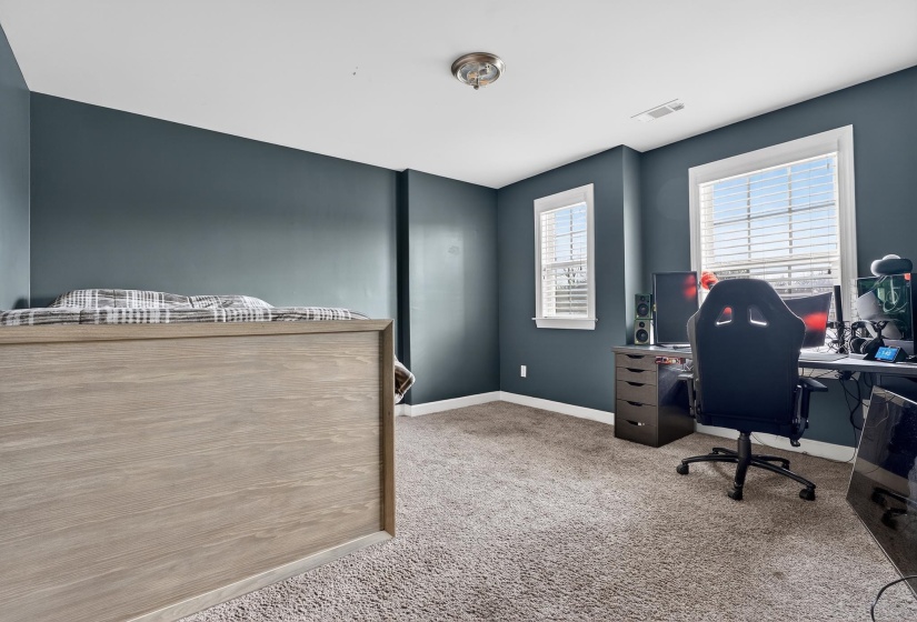 Home office with light colored carpet and baseboards