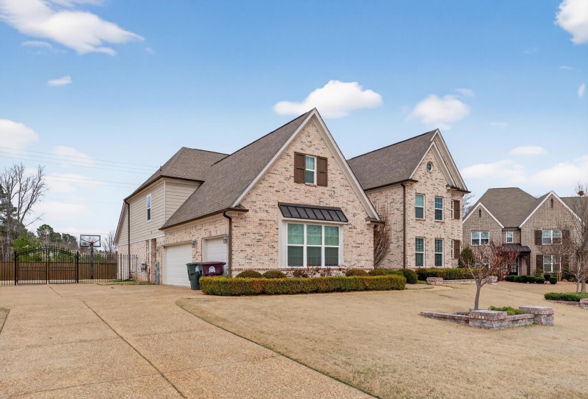 View of front of home with brick siding, driveway, and a shingled roof