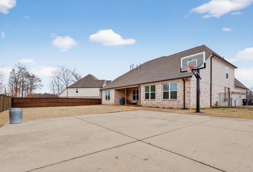 Back of house with a fenced backyard, a shingled roof, a patio, and brick siding