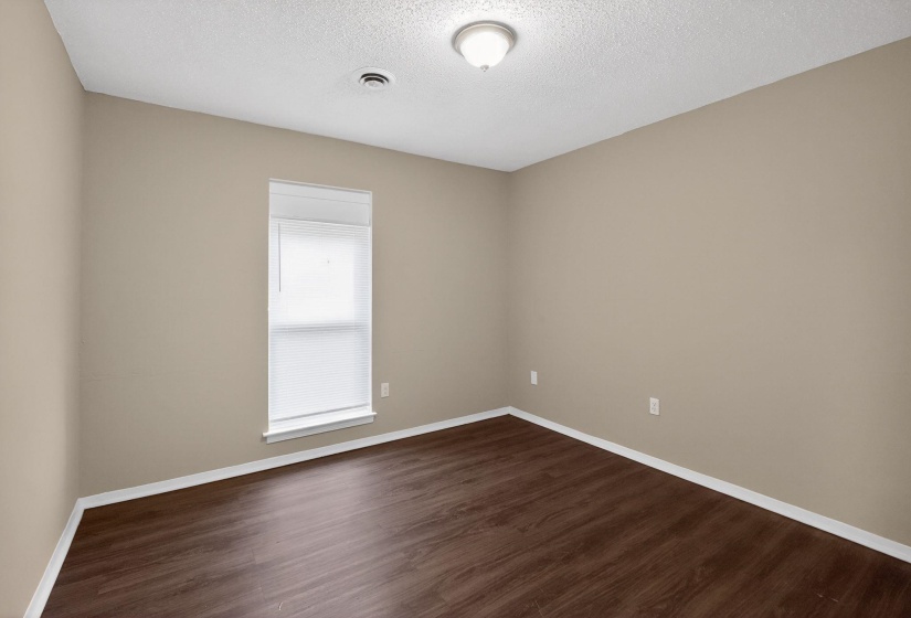 Empty room featuring dark wood finished floors and a textured ceiling