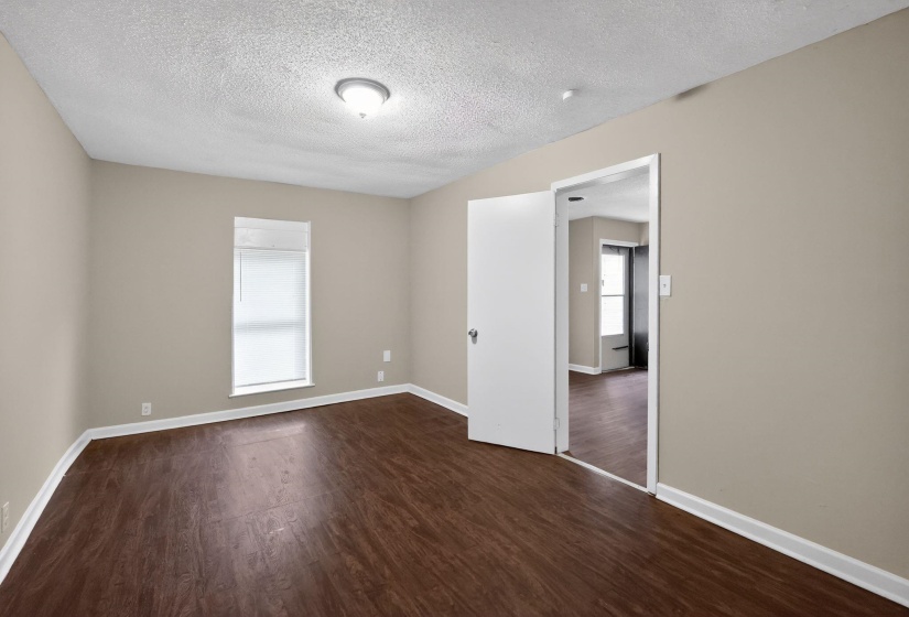 Unfurnished room with dark wood-style flooring and a textured ceiling