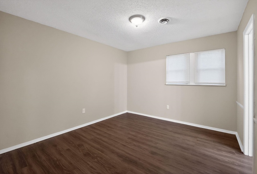 Unfurnished room with dark wood-style floors and a textured ceiling