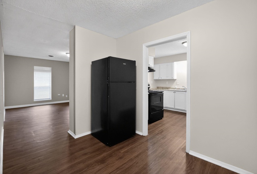 Kitchen with black appliances, white cabinets, a textured ceiling, light countertops, and dark wood finished floors