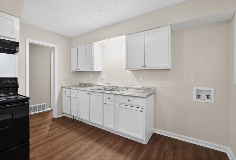 Kitchen featuring electric range, white cabinets, light countertops, dark wood finished floors, and a textured ceiling