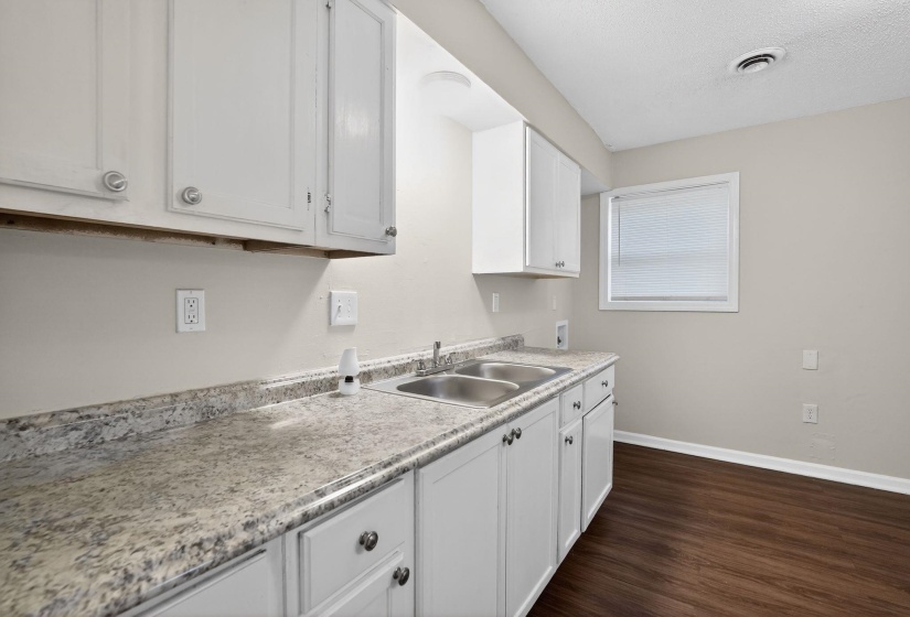 Kitchen with light countertops, white cabinetry, dark wood-style floors, and a textured ceiling