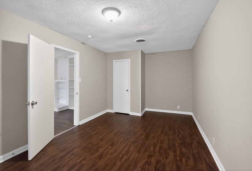 Unfurnished bedroom featuring dark wood finished floors and a textured ceiling