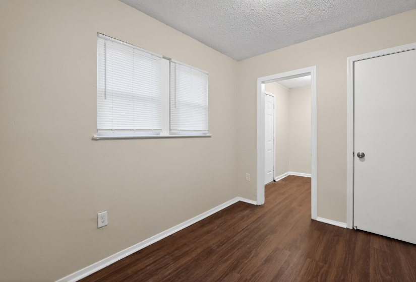Unfurnished bedroom featuring dark wood-style floors and a textured ceiling