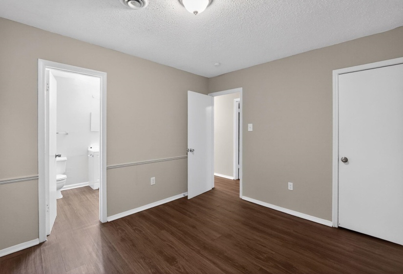 Unfurnished bedroom featuring dark wood-style floors and a textured ceiling
