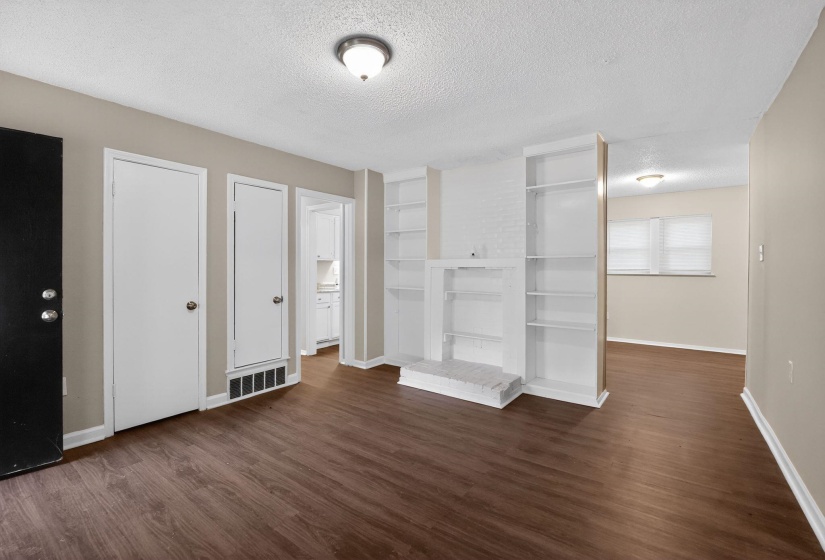 Unfurnished bedroom featuring a textured ceiling, dark wood-type flooring, and a closet
