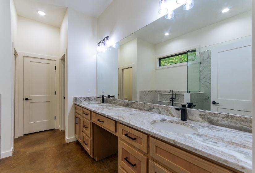 Full bath featuring double vanity, finished concrete floors, recessed lighting, and a marble finish shower
