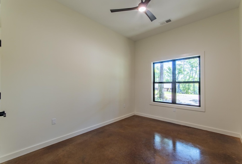 Empty room featuring concrete floors and ceiling fan