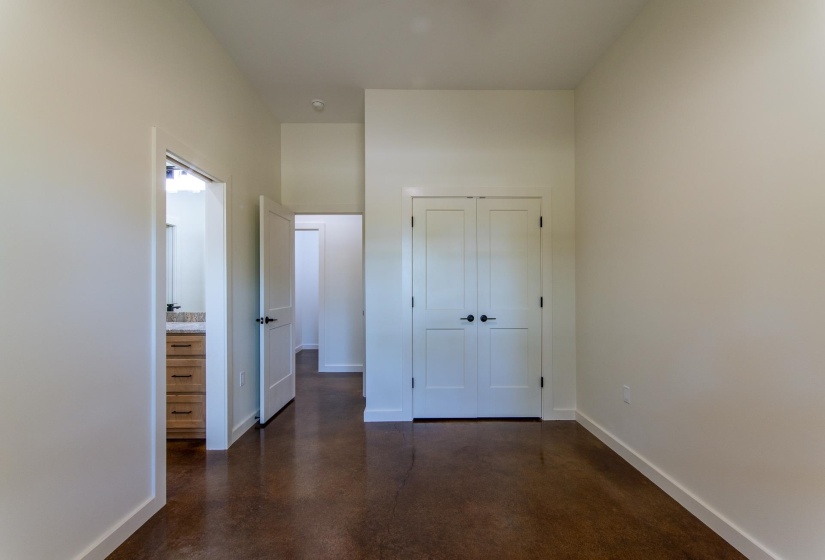 Unfurnished bedroom featuring concrete flooring and a closet