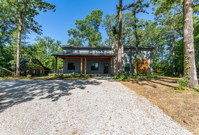 View of front facade with board and batten siding, a metal roof, and a porch
