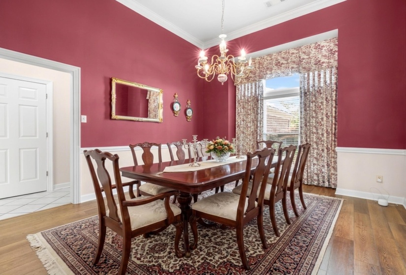 Dining space featuring wood-type flooring, a chandelier, and crown molding