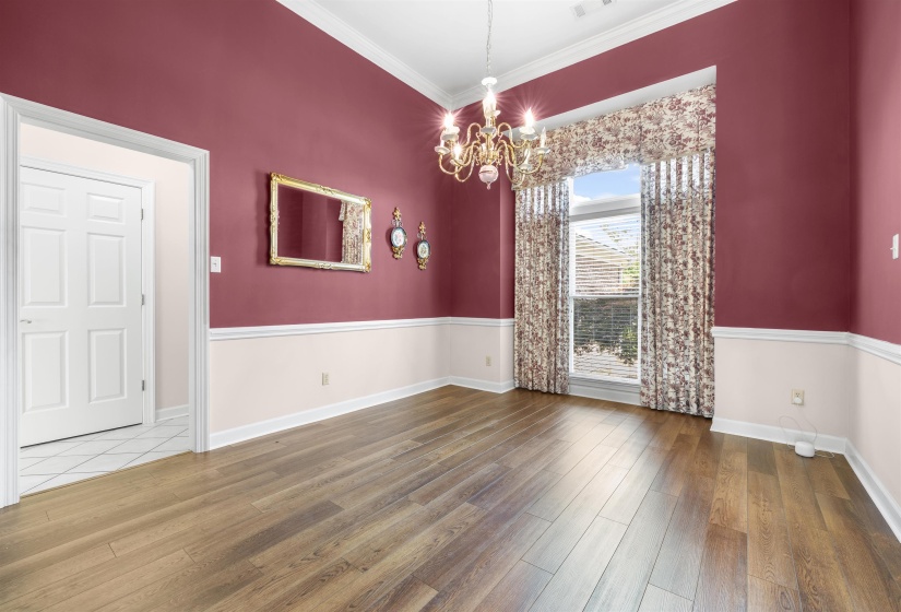 Unfurnished dining area featuring hanging lights, wood finished floors, and ornamental molding