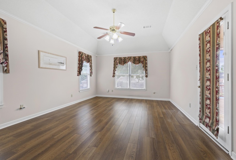 Master Suite  with a ceiling fan, dark wood-style floors, ornamental molding, and vaulted ceiling