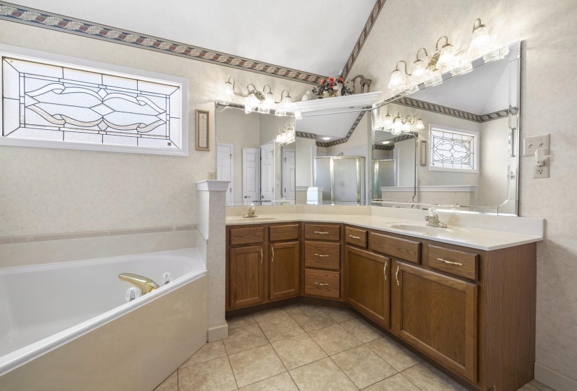 Bathroom with double vanity, a garden tub, wallpapered walls, and light tile patterned floors