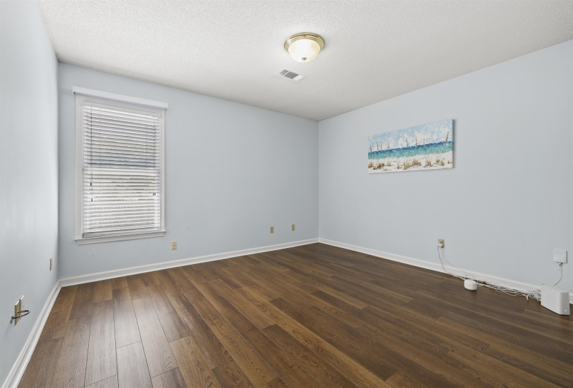 Spare room featuring dark wood-type flooring and a textured ceiling