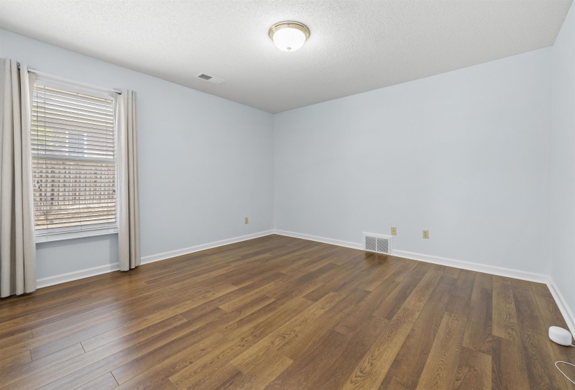 Bedroom with dark wood-style flooring and a textured ceiling