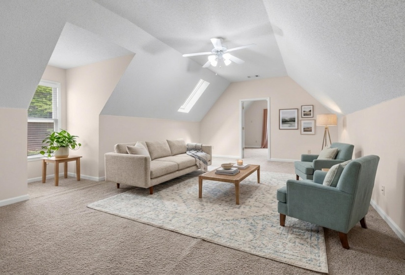 Bonus room with a textured ceiling, a skylight, a ceiling fan, and light carpet