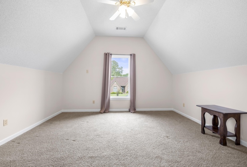 Bedroom with light carpet, a textured ceiling, and a ceiling fan