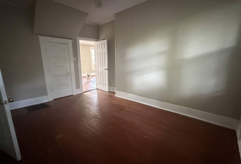 Unfurnished bedroom with dark wood-type flooring and baseboards