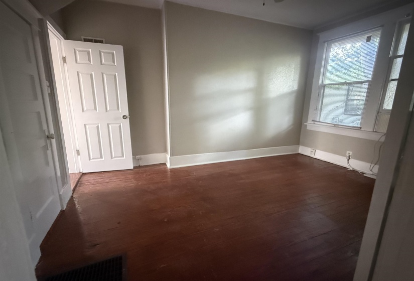 Spare room featuring dark wood finished floors and baseboards