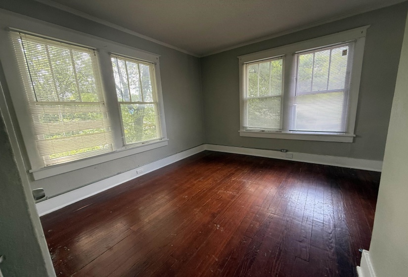 Unfurnished room with dark wood-style flooring and ornamental molding