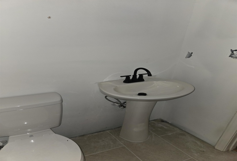 Half bathroom featuring tile patterned floors and toilet