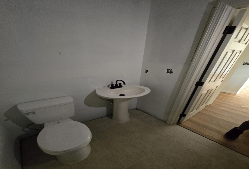 Half bath featuring toilet and light tile patterned flooring