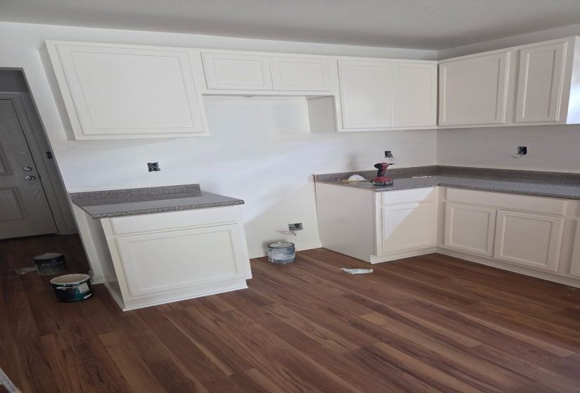 Kitchen featuring white cabinetry and dark wood finished floors