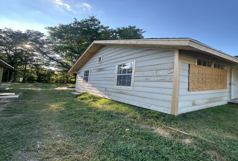 View of side of property featuring a lawn