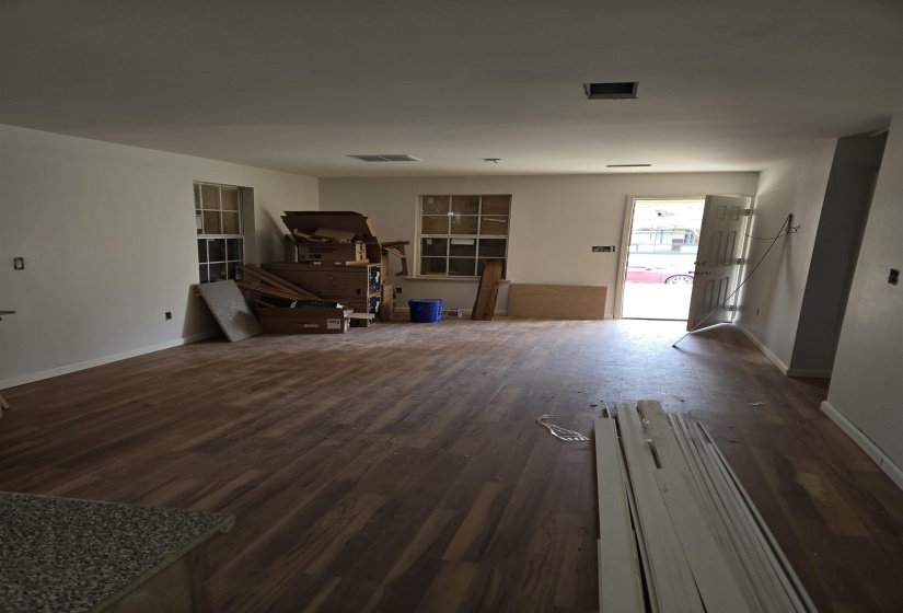 Unfurnished living room with baseboards and dark wood finished floors