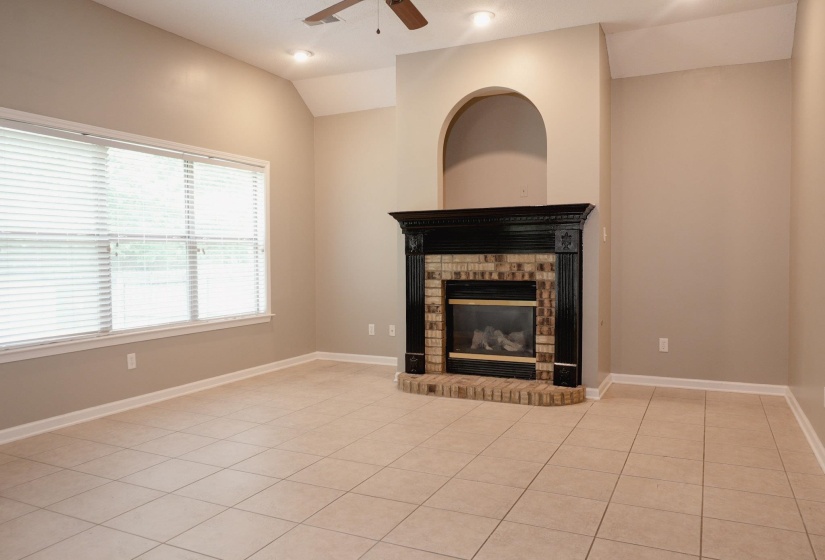 Unfurnished living room featuring lofted ceiling, light tile patterned floors, a ceiling fan, a fireplace, and recessed lighting